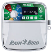 Rain Bird ESP-TM2 irrigation controller with a digital display, multiple buttons for settings and programming, and the Rain Bird logo at the bottom.