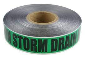 A roll of green detectable storm drain marking tape with 'STORM DRAIN' text printed on it.