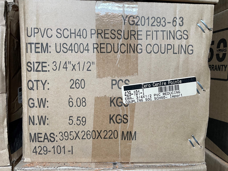 A close-up of a cardboard shipping box printed with product details for UPVC SCH40 pressure fittings, including item number US4004 reducing coupling, size 3/4" x 1/2", quantity 260 pieces, and weight information. A barcode label is visible on the front.