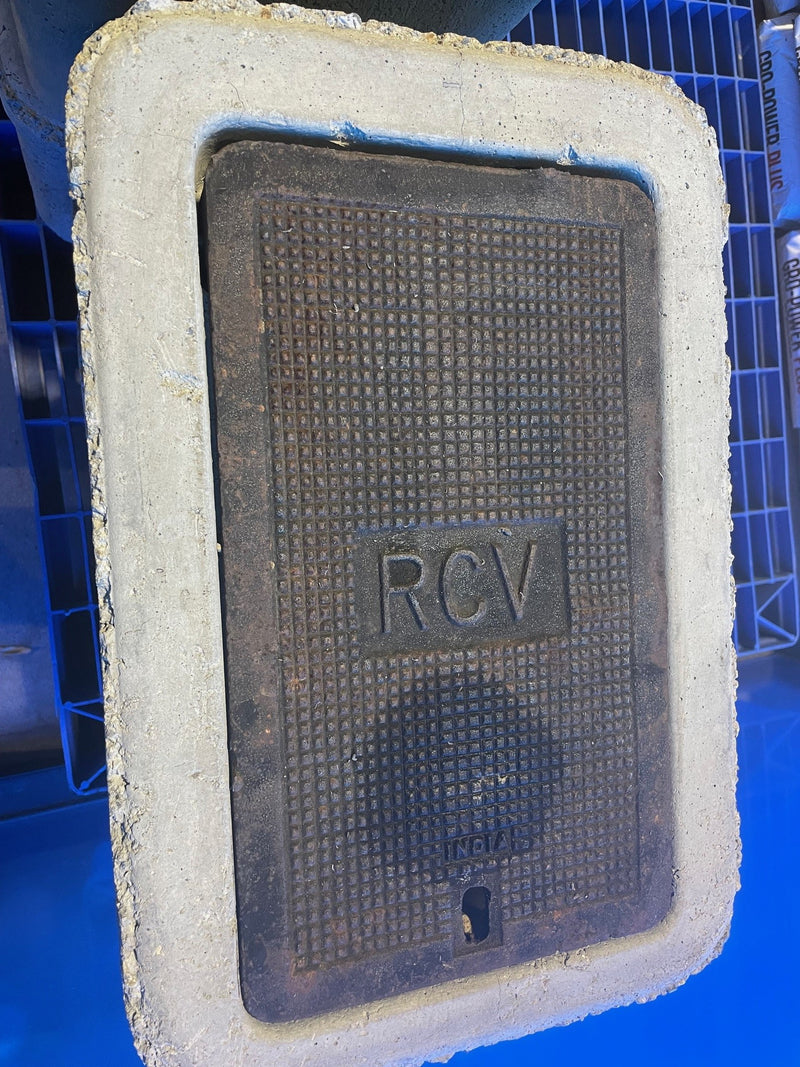 Rectangular metal cover with 'RCV' marking on a blue background