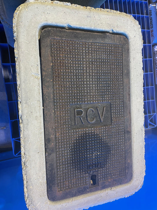 Rectangular metal cover with 'RCV' marking on a blue background