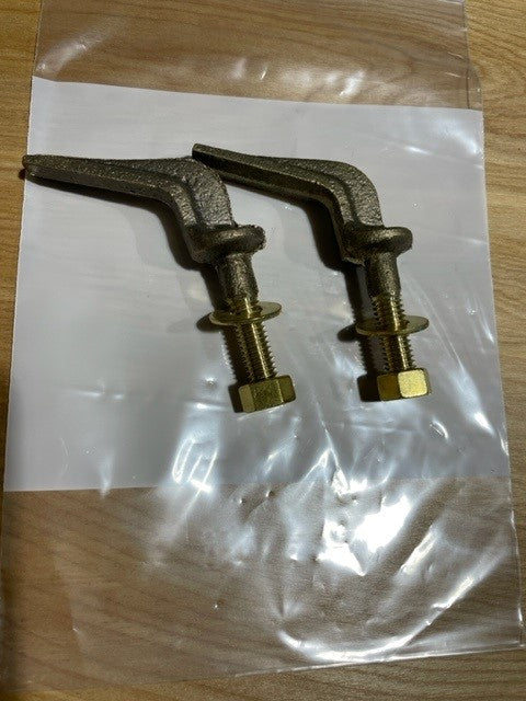 Two brass bolts in a clear plastic bag on a wooden surface