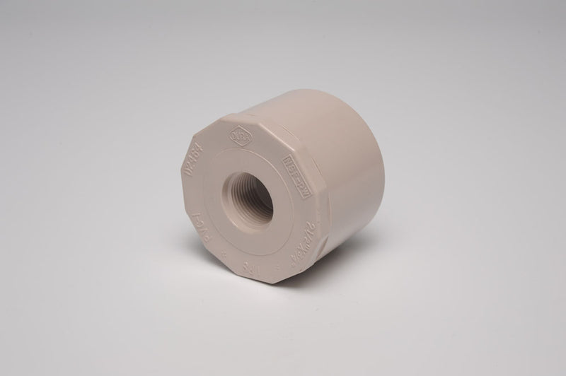 A beige 1"X3/4" R Bushing SPG/FPT UVR PVC fitting against a white background.