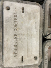 A gray concrete pull box lid with the words 'SPRINKLER CONTROL' written on it.