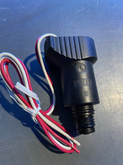 Black electrical connector with wires on a metallic surface