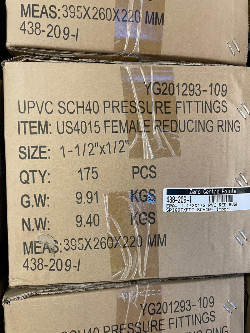 A close-up of stacked cardboard shipping boxes containing UPVC SCH40 pressure fittings, with printed product details and barcodes visible on the boxes.