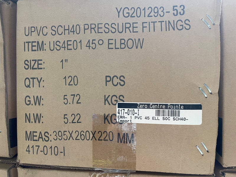 A brown cardboard shipping box printed with product details for UPVC SCH40 pressure fittings, specifically a 1-inch 45-degree elbow. The box lists quantity, weight, dimensions, and a barcode label from Zero Centre Pointe.
