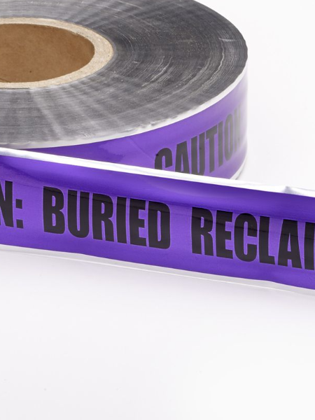 A roll of detectable purple marking tape with the words 'CAUTION: BURIED RECLAIM LINE' printed on it, indicating it is used for marking reclaimed or buried water lines.