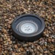 Round black object on a gravel surface