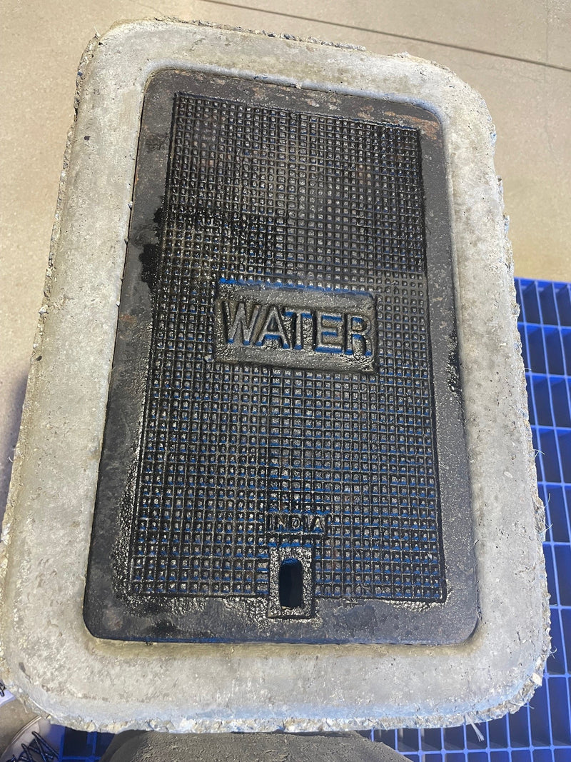 Black mat with 'WATER' text on a white foam block, on a blue grid background.