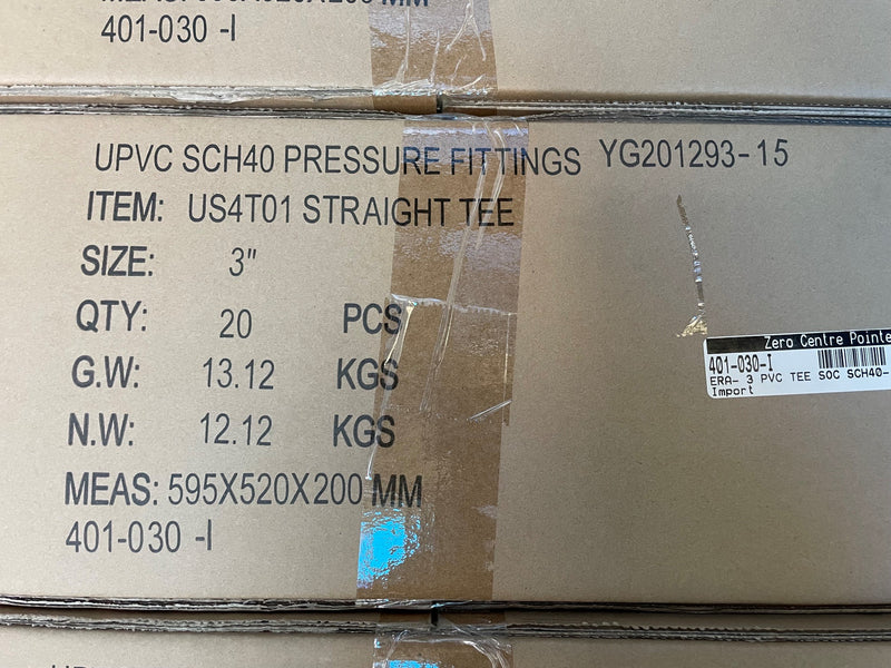 A close-up of a brown cardboard shipping box printed with product details for UPVC SCH40 pressure fittings, including item number US4T01 STRAIGHT TEE, size 3 inch, quantity 20 pieces, and weight information.