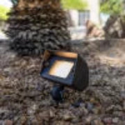 Solar light fixture on a stone surface with trees in the background