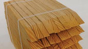 A stack of brown wooden fence stakes with a chisel point, used for erosion control.