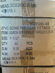 A close-up of stacked cardboard boxes containing UPVC SCH40 pressure fittings, with printed specifications including female thread elbow, size 1-1/2 inches, quantity 44 PCS, and weight details.