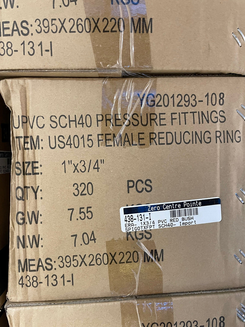 A close-up of stacked brown cardboard shipping boxes with printed product information for UPVC pressure fittings, including size, quantity, weight, and a barcode label.