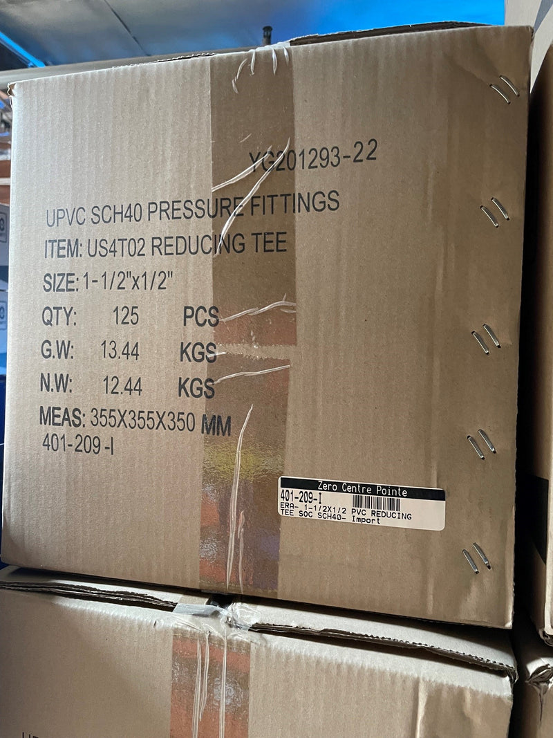 A large brown cardboard shipping box for UPVC SCH40 pressure fittings, specifically a reducing tee, with printed specifications and a barcode label.
