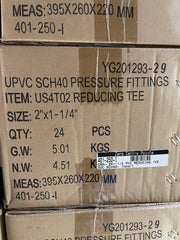 A close-up of stacked brown cardboard shipping boxes printed with product details for UPVC SCH40 pressure fittings, specifically a reducing tee item with size, quantity, and weight information.