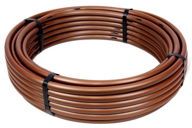 A coil of brown, flexible dripline tubing for irrigation systems.