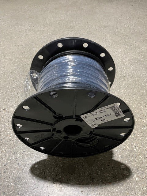 A spool of black irrigation wire on a gray background.
