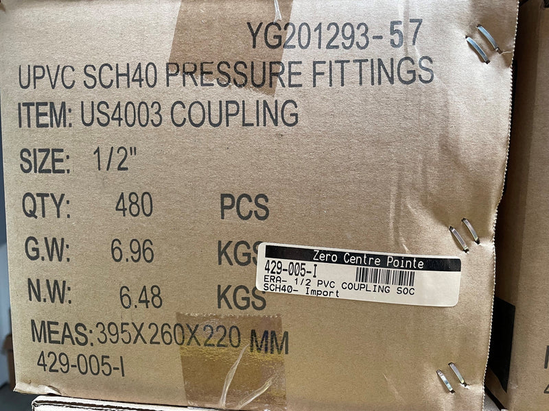 A close-up of a brown kraft paper shipping box printed with product details for UPVC SCH40 pressure fittings, item US4003 coupling, size 1/2 inches. The box shows quantity 480 PCS, gross weight 6.