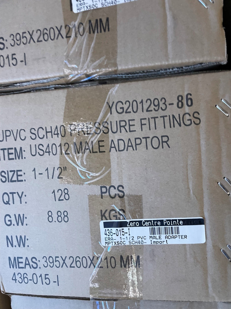 A close-up of stacked brown cardboard shipping boxes with printed black text and a white barcode label. The visible text references 'UPVC SCH40 PRESSURE FITTINGS', 'US4012 MALE ADAPTOR', size 1-1/2", quantity 128 PCS, and measurements 395x260x210 mm.