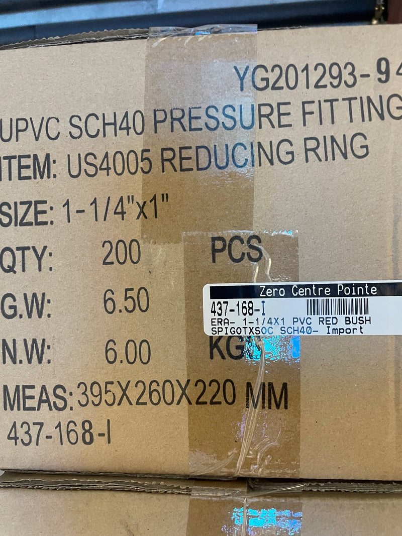 A close-up of a cardboard shipping box printed with product details for a UPVC SCH40 pressure fitting, including item number YG201293-9, size 1-1/4"x1", quantity 200, and a barcode label from Zero Centre Pointe.