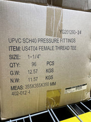 A brown cardboard shipping box printed with product details for UPVC SCH40 pressure fittings, specifically a female thread tee, size 1-1/4 inches, with quantity and weight information.