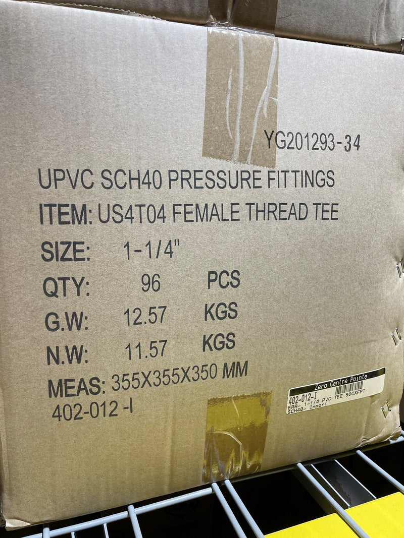 A brown cardboard shipping box printed with product details for UPVC SCH40 pressure fittings, specifically a female thread tee, size 1-1/4 inches, with quantity and weight information.