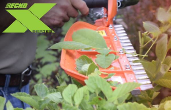 Person using an Echo hedge trimmer on plants with the Echo logo visible.