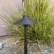 Black outdoor light fixture on a grassy area