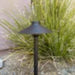 Black outdoor light fixture on a grassy area