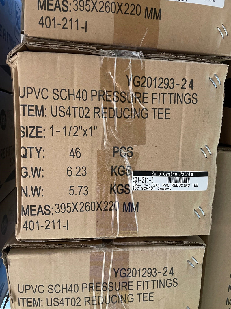 Stacked cardboard shipping boxes for UPVC SCH40 pressure fittings, showing printed product details, size, quantity, and a barcode label.