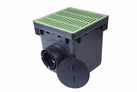 A black rectangular catch basin with a green grate on top, accompanied by a black outlet and a plug.