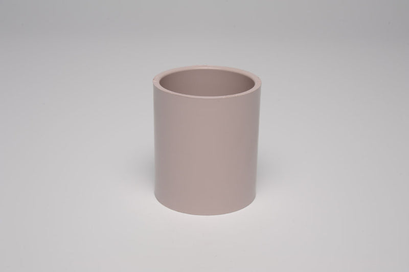 A beige 1" coupling SS UVR PVC fitting against a white background.