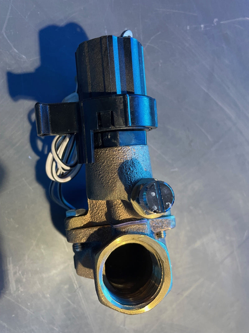 Brass valve with blue and black components on a metallic surface