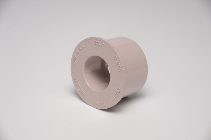 A beige 2 inch by 1-1/2 inch R Bushing for irrigation systems.