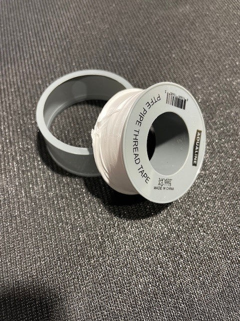 Spool of PTFE pipe thread tape on a textured gray background