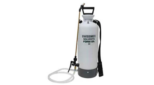 A white 3 gallon solvent/form oil sprayer with a brass nozzle and a black shoulder strap.