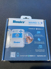 Hunter WAND smart irrigation controller packaging box, featuring blue and white design with product graphics and Hydravise branding, photographed on a dark textured surface.